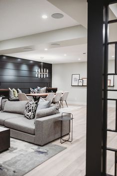 a living room filled with furniture next to a dining table and stairs in the background