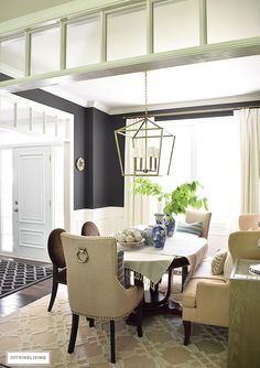 a dining room table with chairs and a chandelier hanging from it's ceiling