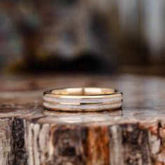 two wedding bands sitting on top of a piece of wood