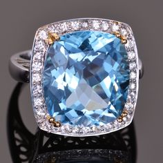 This ring's electric Blue Topaz center stone is a massive 17.97 carats surrounded by .60 carats of dazzling diamond cut white sapphires. Beautifully cast in solid 14K white gold. The dimensions of this ring are 20mm x 19mm. Ring size is a 7.  Additional sizes available upon request. Luxury White Gold Diamond Ring With Blue Topaz, Luxury Rings With Blue Topaz And Polished Finish, Luxury Dazzling White Topaz Diamond Ring, Luxury Blue Topaz Jewelry With Brilliant Cut, Luxury White Topaz Ring With Diamond Accents, Luxury Hallmarked Blue Topaz Jewelry, Cocktail Jewellery, Sapphire Cocktail Ring, Cocktail Jewelry