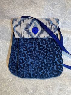 What makes this adorable little purse perfect? The purse body features a rich blue animal pattern plush weave with a geometric jacquard flap. Made from upcycled fabrics throughout, it also features a linen blend lining. For a little bag, the purse has so much room! It's organized with a main inner pouch, a back pouch (for easy access to phone) and 2 outer front pouches. You wouldn't believe how much fits inside! It closes with a  magnetic snap closure so everything stays inside.  Measurements: 9 Blue Shoulder Bag With Cell Phone Pocket, Blue Shoulder Bag With Cell Phone Pocket For Gift, Blue Fabric Bag With Removable Pouch, Blue Fabric Shoulder Bag, Blue Fabric Shoulder Bag For Travel, Small Cross Body Bag, Everything Stays, Body Features, Small Crosses