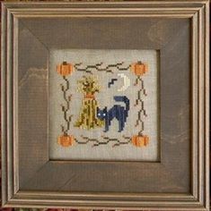 a cross stitch picture frame with an elephant and pumpkins on it