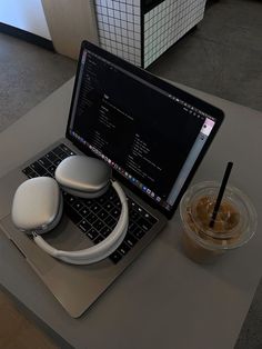 an open laptop computer sitting on top of a table next to a cup of coffee