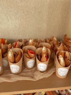 there are many different types of pastries in cups on the table with paper wrappers