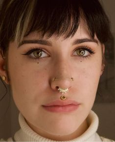 a woman with piercings on her nose looking at the camera