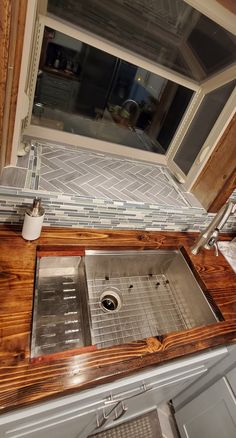 a kitchen sink with a wooden counter top