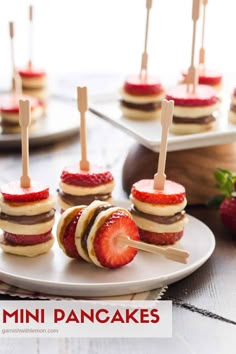 strawberries are arranged on small appetizers with toothpicks