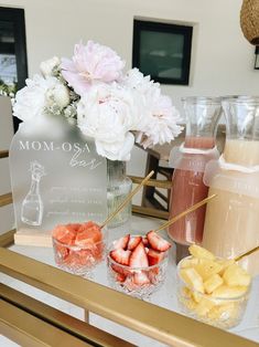 there are some drinks on the table with strawberries and pineapples in front of them