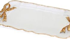 a white and gold tray with bows on the handles is shown in front of a white background