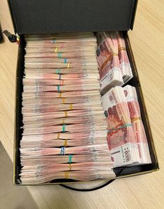 a briefcase filled with lots of money sitting on top of a wooden table