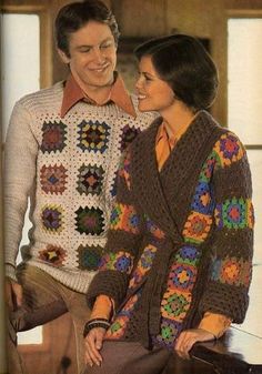 a man and woman sitting next to each other wearing crocheted sweaters with flowers on them