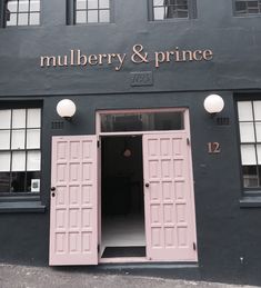 the entrance to mulberry and prince restaurant with pink doors on it's side