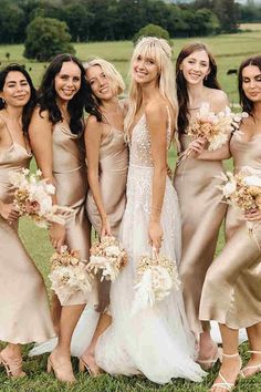 a group of women standing next to each other on top of a lush green field