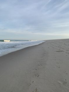 footprints in the sand on an empty beach