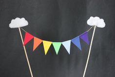 a cake that is sitting on top of a table with some flags and clouds in the background