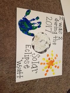 two handprints are on the ground next to a sign that says earth day