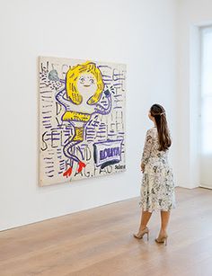 a woman standing in front of a painting on the wall next to a wooden floor