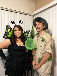 the man and woman are dressed up as bugs for halloween costumes, one is holding a green frisbee