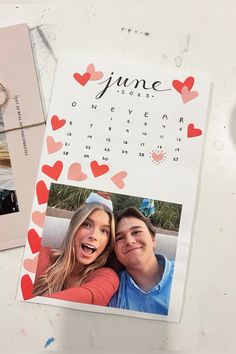 a calendar with hearts on it next to a couple