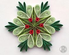 an origami christmas decoration with green leaves and red berries on white background, top view