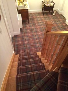 the stairs are made of wood and plaid carpet