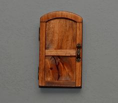 a wooden clock mounted to the side of a wall next to a gray wall with a horse head on it