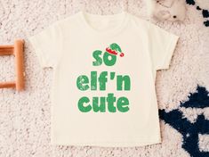 So Elf'in Cute Toddler Shirt, Kids Christmas Shirt, Toddler Christmas Shirt, Cute Kids Christmas Shirts, Holiday Shirts, Natural Toddler Tee 💗  Welcome to The WildflowerbyMiley Etsy Shop!  This listing is for the bodysuit, sweatshirt or t-shirt only. All other items that are shown in our photos such as shoes, hats, beanies, blankets etc. are for photo staging purposes and are NOT INCLUDED in the sale. DESCRIPTION:  This baby and children's unisex essential fits like a well-loved favorite. Super soft t-shirts, sweatshirts and baby bodysuits for your little lads and gals meant to showcase their big personalities. Its Excellent quality and vibrant print makes one fall in love with it over and over again.  This adorable piece is the perfect lightweight layer for casual wearing.  This product Kids Christmas Shirts, Kids Christmas Shirt, Toddler Christmas Shirt, Christmas Shirts For Kids, Toddler Christmas, Toddler Tees, Holiday Shirts, Christmas Shirt, Kids Christmas