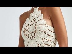 a woman wearing a white crochet halter top