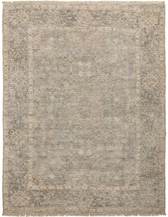 an antique rug with grey and beige colors