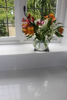 a vase filled with flowers sitting on top of a window sill