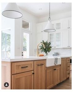 a kitchen with wooden cabinets and white counter tops, along with an island in the middle