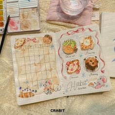 an open notebook with drawings on it next to other items