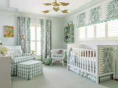 a baby's room decorated in green and white with palm leaves on the curtains