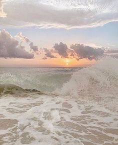 a person riding a surfboard on top of a wave in the ocean at sunset