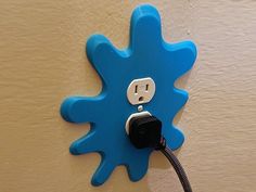 an electric outlet plugged into a blue flower design wall plate with a black cord