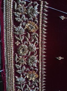 a red velvet jacket with gold embroidered flowers on it