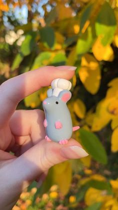 a person holding a tiny toy mouse in their hand