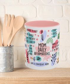 a coffee mug with the words mom daily affirmations on it next to a canister