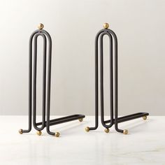 two black metal racks with gold balls on them