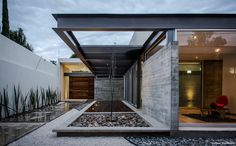 the entrance to a modern home with water feature