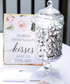 there is a sign that says guess how many kisses are in the jar next to it