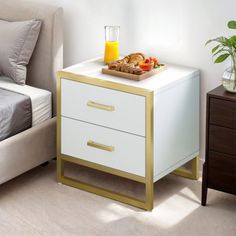 a bed and nightstand in a room with a tray of food on top of it