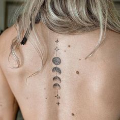 the back of a woman's neck with three phases of the moon and stars on it