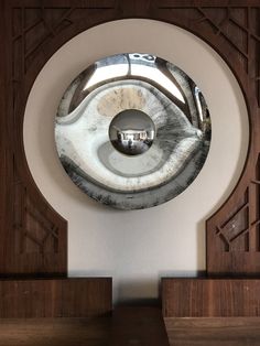 a circular mirror mounted to the side of a wall