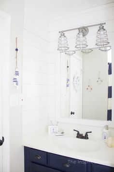 a bathroom with a white sink and blue cabinets