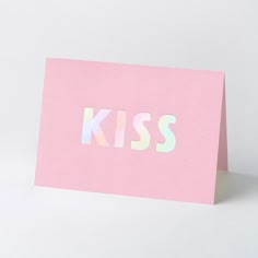 a pink card with the word kiss printed on it