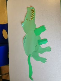 a paper cut out of a green lizard