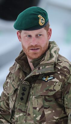 a man in camouflage is wearing a green beret