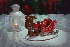 a christmas sleigh with a lit candle in the middle and a lantern on top