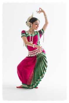 a woman in a pink and green dress dancing